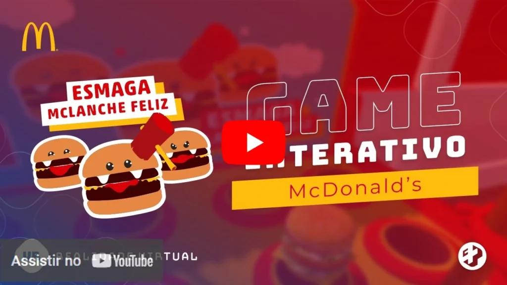 Imagem promocional do jogo “Esmaga McLanche Feliz” da McDonald’s em realidade virtual, com hambúrgueres caricatos e marreta ilustrada.