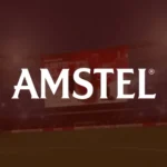 Miniatura de projeto em realidade aumentada (AR) da Amstel, com logotipo branco centralizado sobre fundo em tons de vermelho em ambiente de estádio.